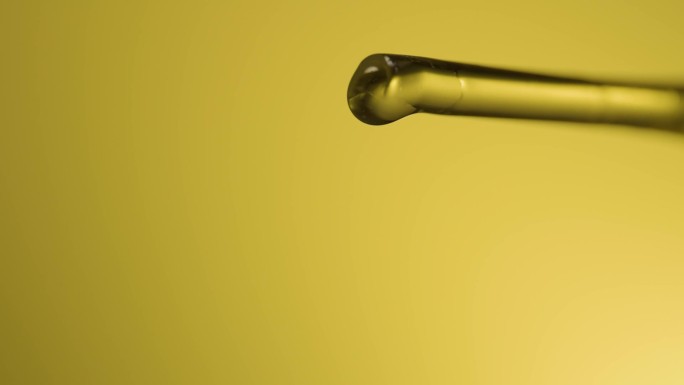 金黄色的油液体从滴管中滴落
