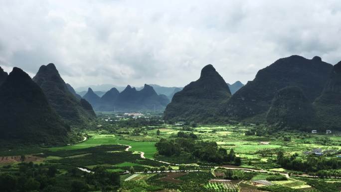 航拍桂林秋天多云喀斯特山峰间的村庄和稻田