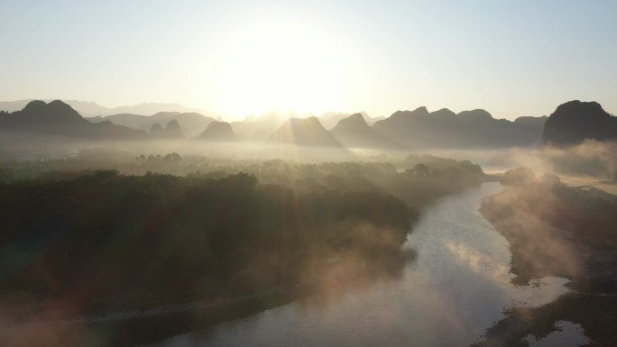 清晨 桂林漓江河滩上的乌桕树和水面上的雾