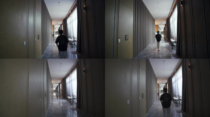 男人走在酒店走廊过道里