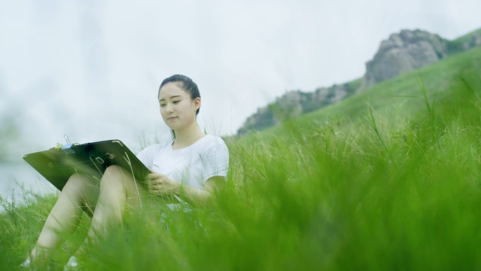 美女草地画画清新户外大自然写生素描