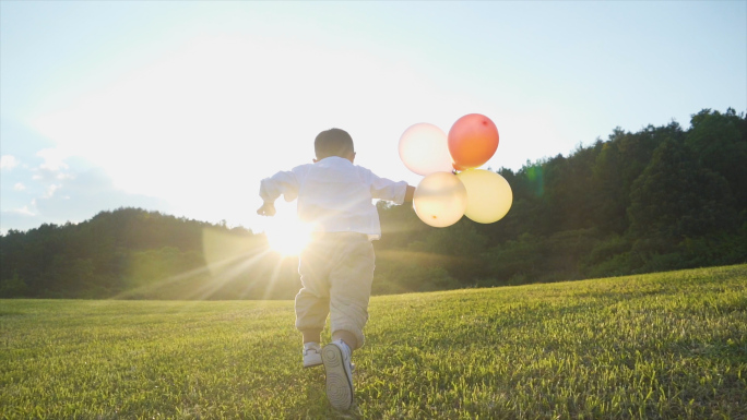 小孩拿着气球草地奔跑欢乐童年时光儿童节
