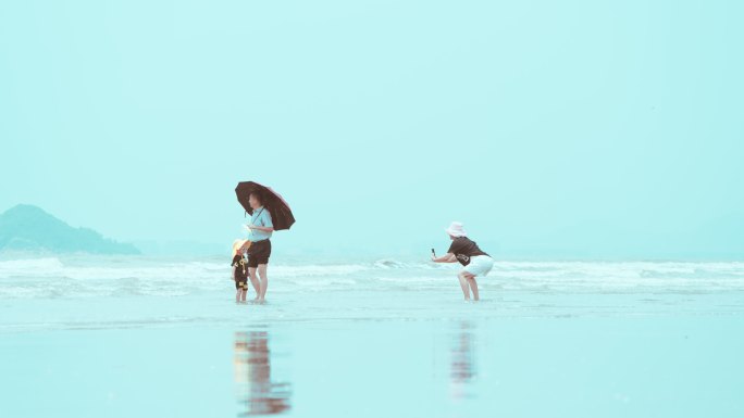 一家三口在海边游玩愉快的拍照-01