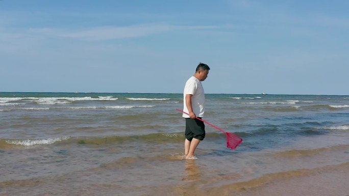 男人海滩拿网兜