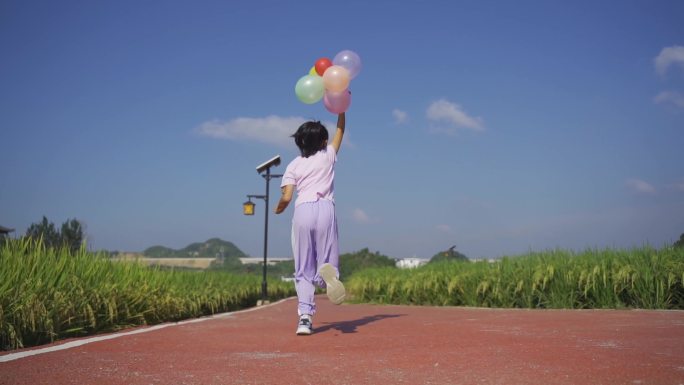 拿着气球草地奔跑欢乐童年时光儿童节