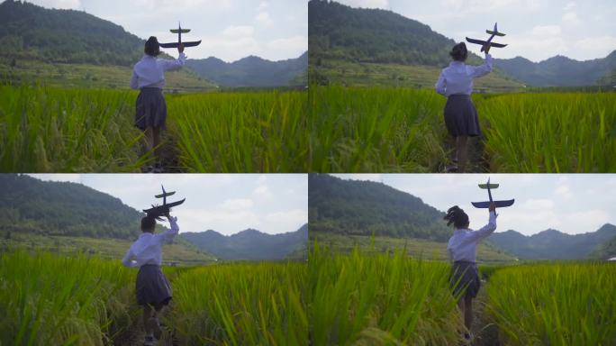 小女孩拿飞机模型稻田奔跑背影童年放飞梦想