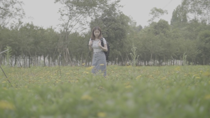 女孩漫步田间欣赏风景闻油菜花野花香灰片