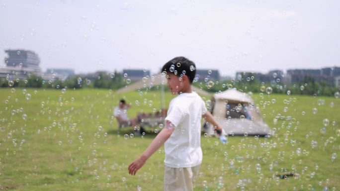 可爱的男孩在户外露营，吹泡泡唯美升格慢镜