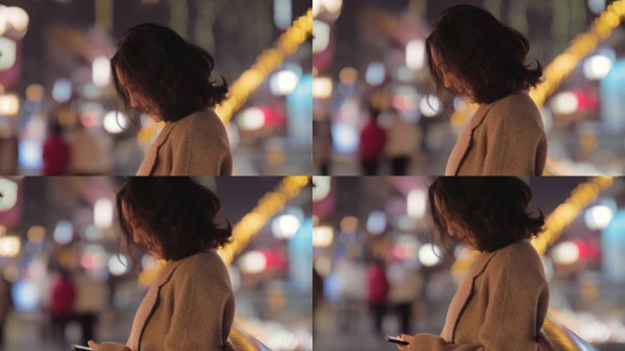 夜晚城市街头美女微笑看手机