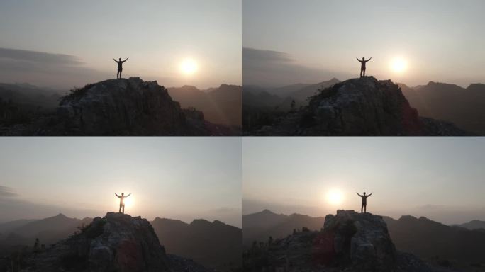 一个人站在山顶张开双臂拥抱太阳向往自由
