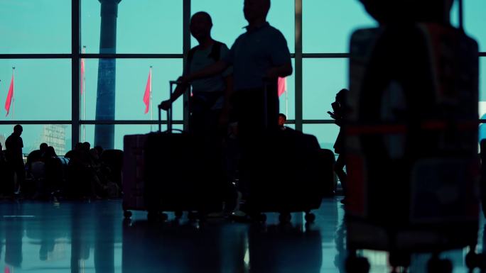 机场大厅里人来人往剪影旅客拖着行李箱行走