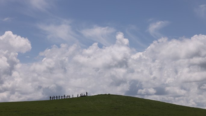 蓝天白云草原小山山顶人群行走天空儿童草地