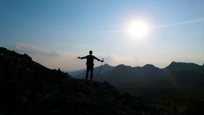 登山者站在山顶举手呐喊向往自由山顶呐喊