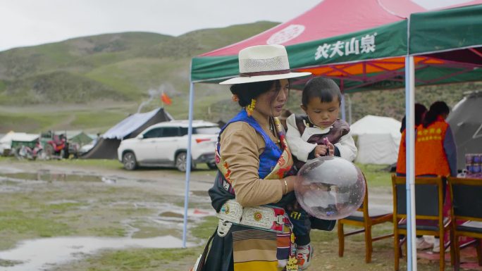 藏族妇女 抱着孩子 给孩子买气球 赶集