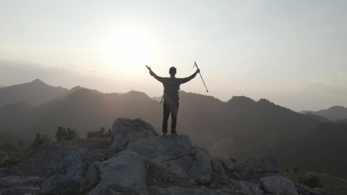 一个人站在山顶张开双臂拥抱梦想希望向自由
