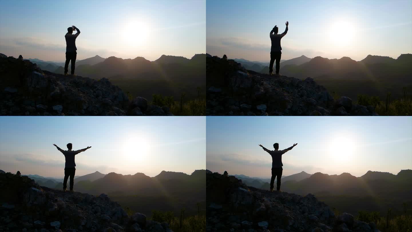 男人站在山顶挥手呐喊释放压力向往自由攀登