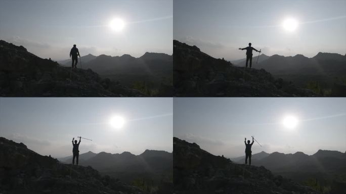 登山者站在山顶举手呐喊向往自由山顶呐喊