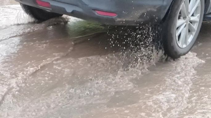 洪水排涝汽车轮子路面水浸汽车开过积水路段