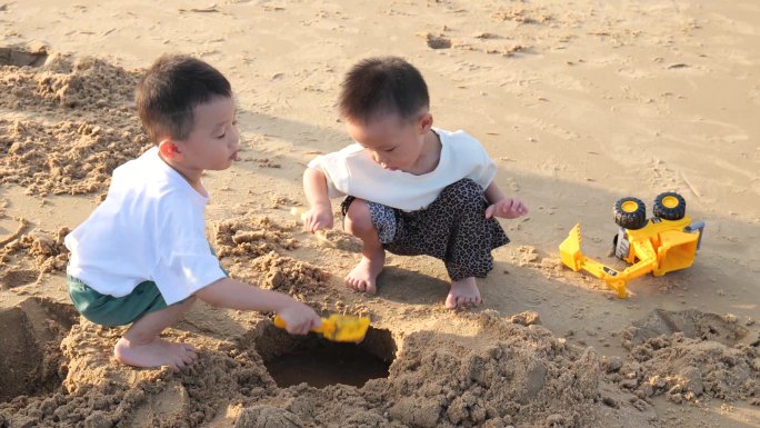 小孩在海边沙滩玩沙子