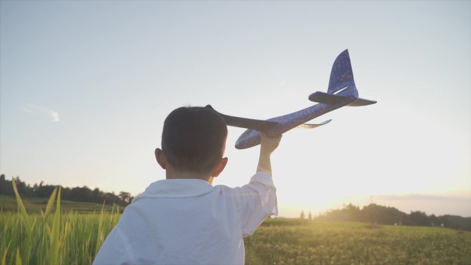 欢乐小男孩拿着飞机模型欢快奔跑幸福时光