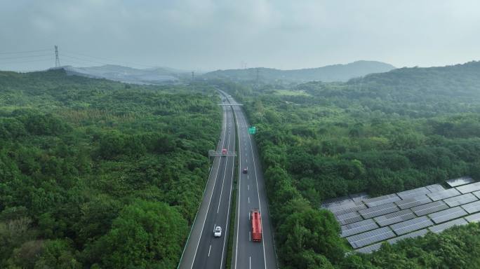航拍高速公路穿过森林和太阳能光伏发电站