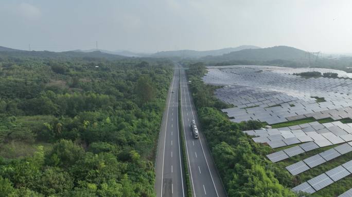 航拍高速公路穿过森林和太阳能光伏发电站