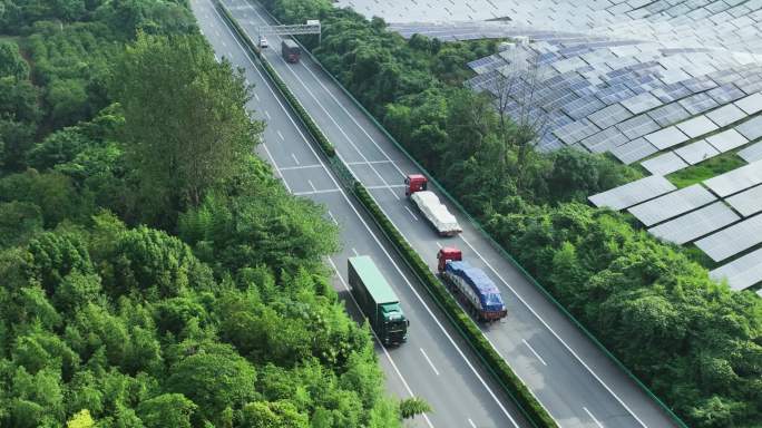 航拍高速公路穿过森林和太阳能光伏发电站