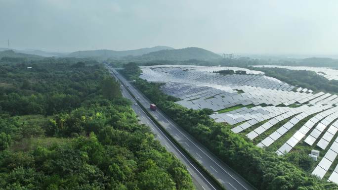 航拍高速公路穿过森林和太阳能光伏发电站
