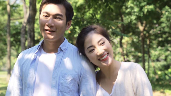 快乐的年轻亚洲情人夫妇在公园里放松一下