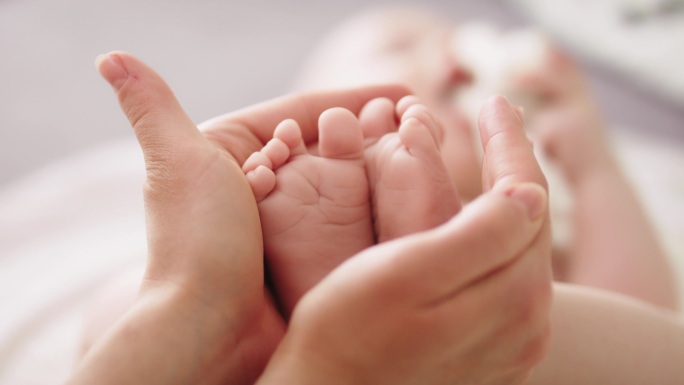 婴儿的脚在母亲的手中。靠近点快乐家庭概念