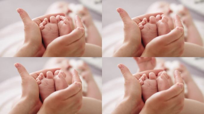 婴儿的脚在母亲的手中。靠近点快乐家庭概念