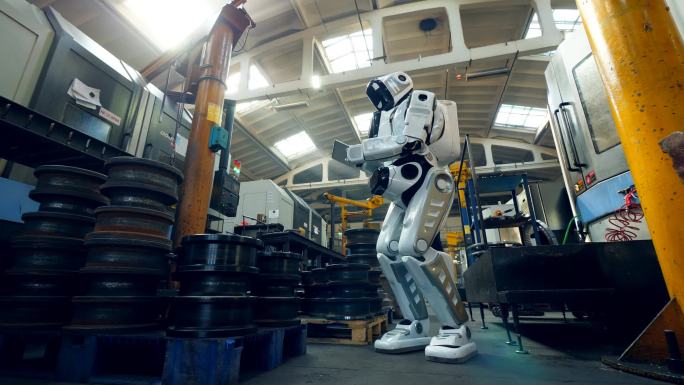 机器人在工厂检查金属件，使用平板电脑.