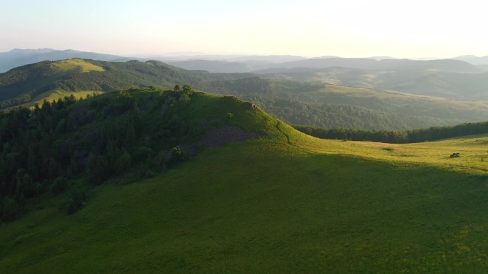 一架无人驾驶飞机飞越高山高地的绿色草地。以UHD视频拍摄。