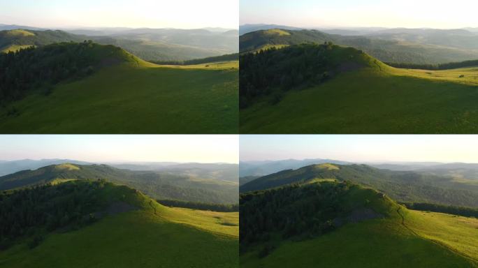 一架无人驾驶飞机飞越高山高地的绿色草地。以UHD视频拍摄。