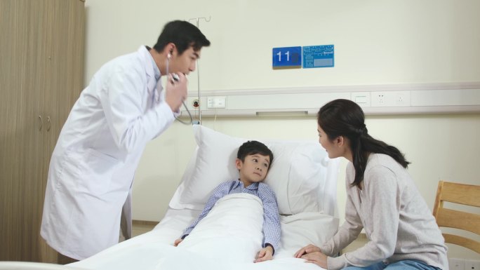 亚洲年轻男医生巡视医院病房，与病童和母亲进行检查和交谈