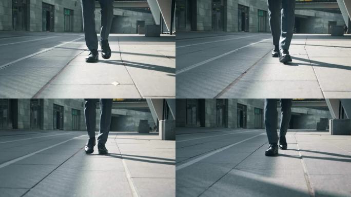 前视图的商人脚穿着黑色的鞋子和正式的衣服走在户外，做台阶，通勤上班，steadicam拍摄。