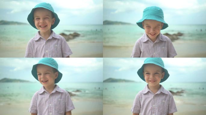 肖像可爱的男孩在帽子笑在海滩上。