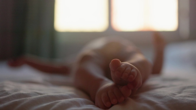 婴儿腿在床上移动的特写镜头。高质量镜头