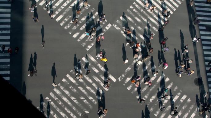 ，在夕阳西下的道路交叉口，俯瞰人群中的人行横道。亚洲人在繁忙的人行横道中的空中景象。 - -丹