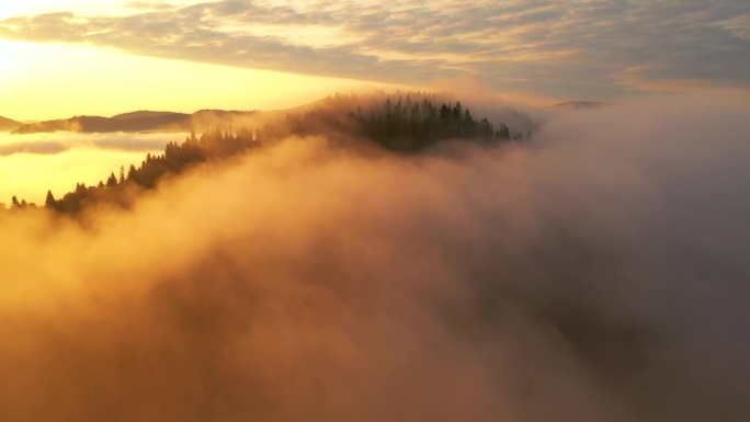 浓浓的浓雾笼罩在晨光中的群山之上.地点：乌克兰喀尔巴阡山脉，欧洲。电影空中拍摄。发现地球的美丽。以，