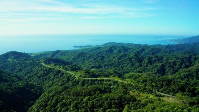 穿过绿林和高山的乡村道路的空中景观