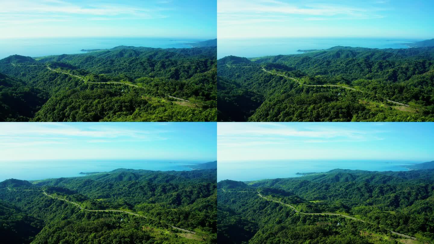 穿过绿林和高山的乡村道路的空中景观