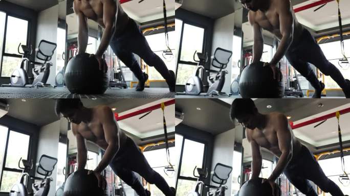 英俊的年轻亚洲肌肉运动员正在健身房锻炼一个药球，60fps
