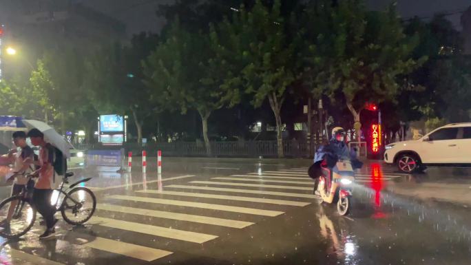 夜晚大雨暴雨斑马线学生自行车放学回家雨伞