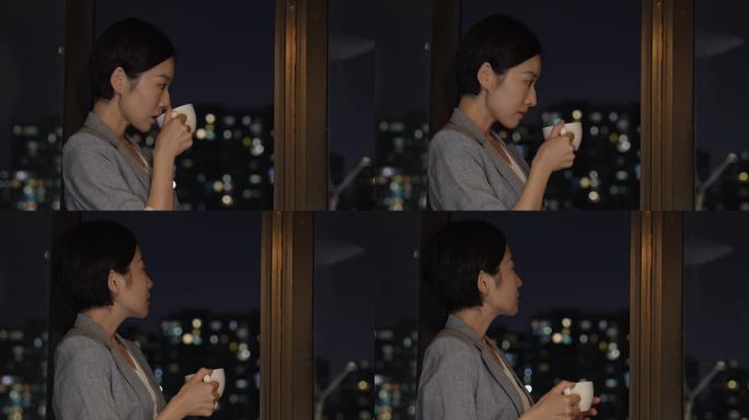 都市女性喝咖啡看着城市夜景
