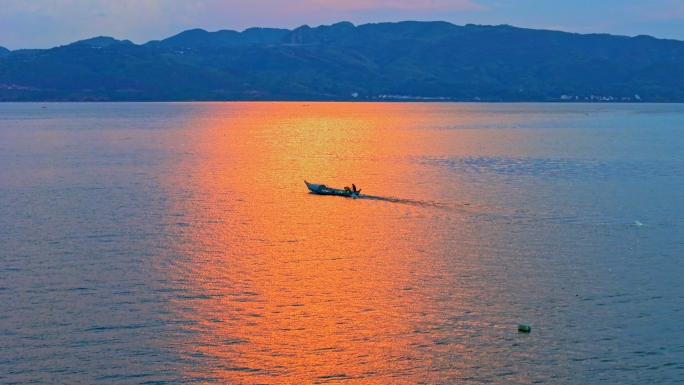 抚仙湖日落下湖面上的渔船