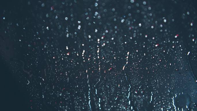 夜晚玻璃上的雨水滑落