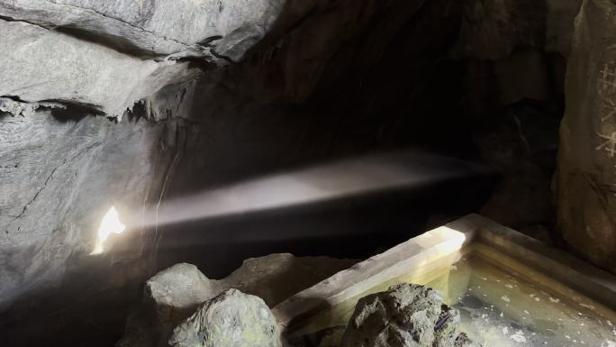 阳光穿过山洞洞口照射到岩壁上丁达尔光