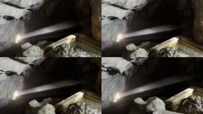 阳光穿过山洞洞口照射到岩壁上丁达尔光