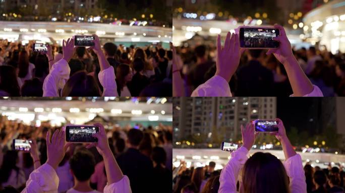 年轻人狂欢露天音乐会女性举着手机录视频